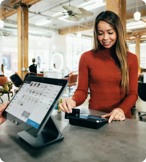 Customer paying at a counter beside a SoftTouch POS screen